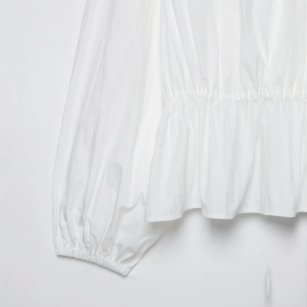 Chaqueta blanca de cuello alto y cintura fruncida